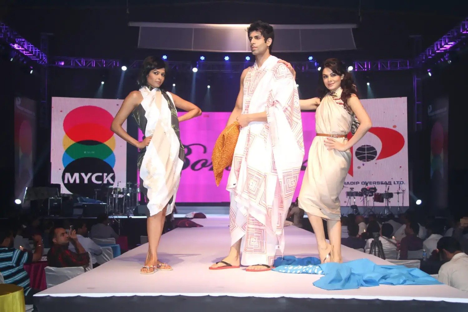 Group of men posing with large cartoon character inflatable figures at night outdoors